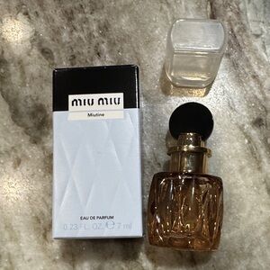Miu Miu Eau de Parfum with Black top and clear Cap and Gold Accents dab on